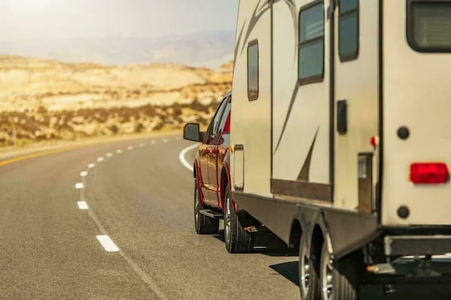 Shipping an RV with a red truck.