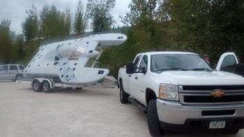 A white truck with a boat attached to it.