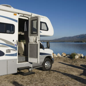 An RV parked on the shore, nearby RV transport companies.