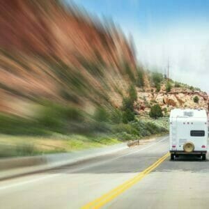 A blurry image of an RV driving down a mountain road.