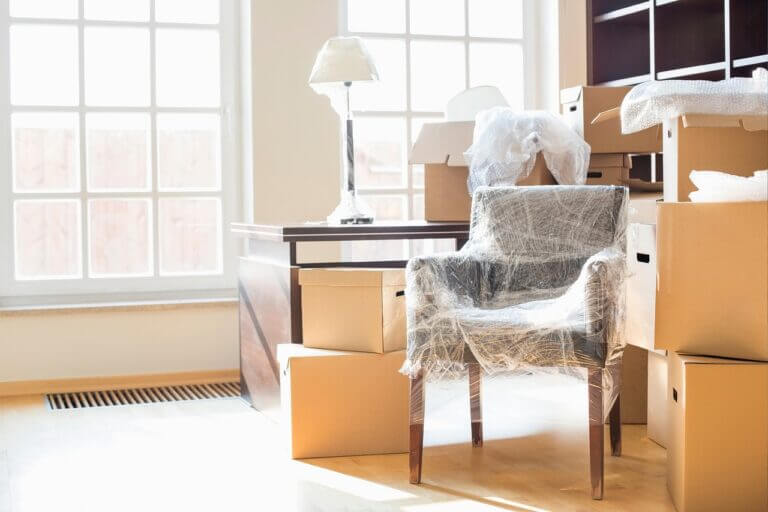 A room filled with boxes and a chair, featuring a furniture shipping cost calculator.