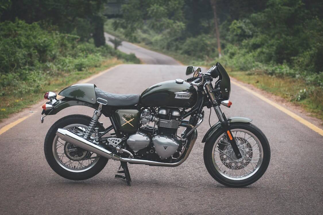 A motorcycle is parked on the side of a road, and there is a cost to ship it.